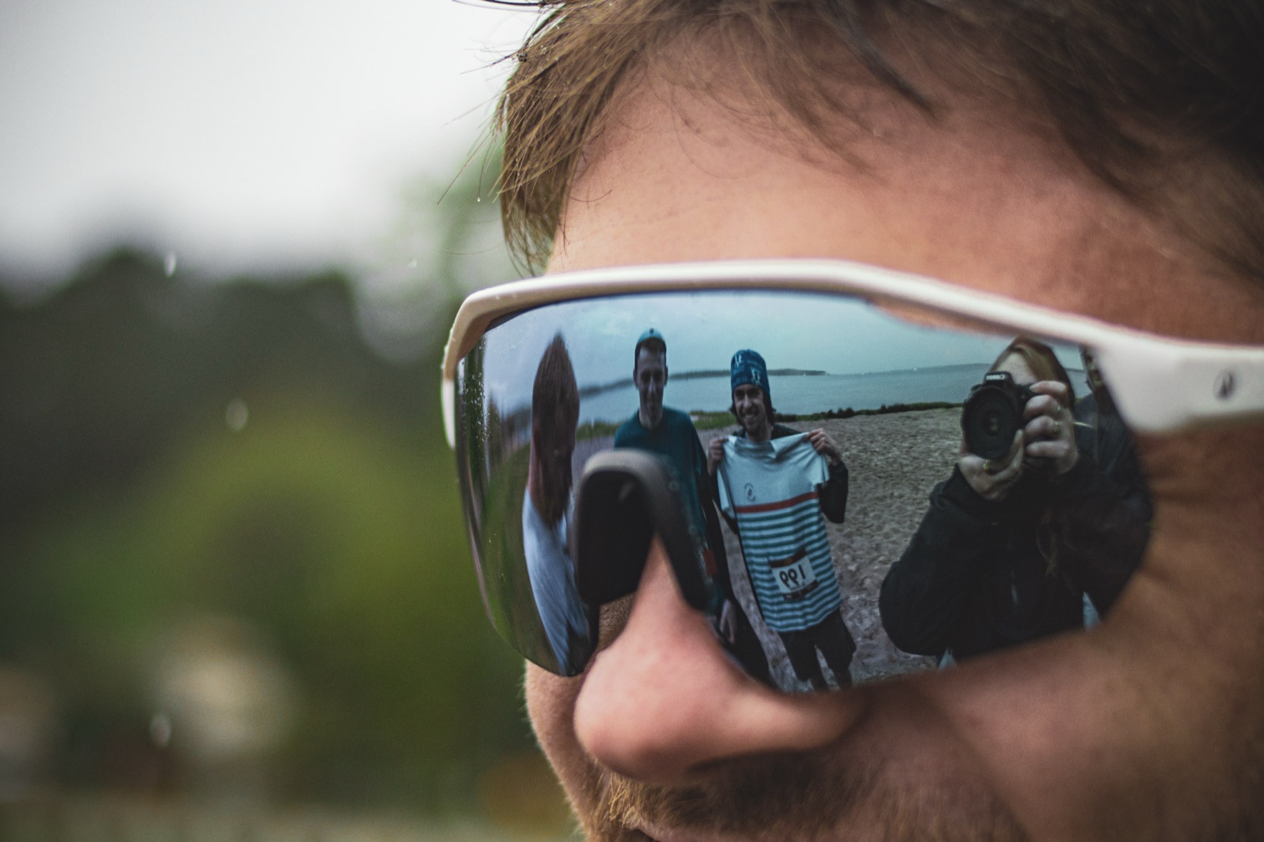Voluntarios reflejados en las gafas de un corredor
